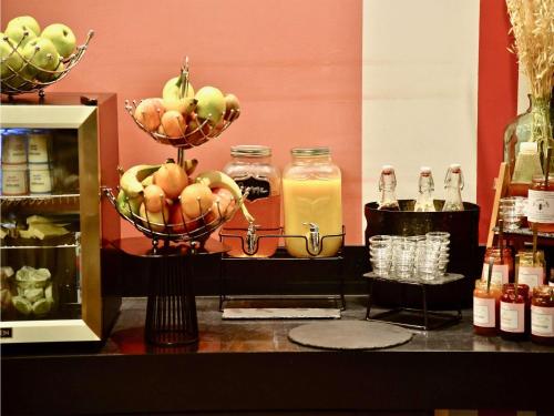 a counter with bottles of juice and a bowl of fruit at Mercure Cholet Centre in Cholet