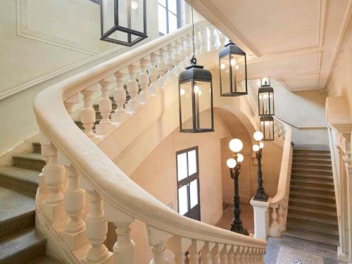 a spiral staircase in a home with chandeliers at Mercure Cholet Centre in Cholet