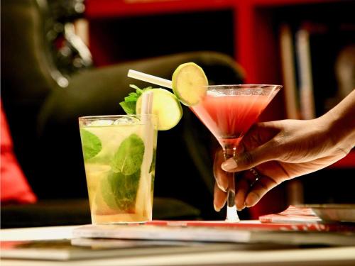 a person holding a drink on a table at Mercure Cholet Centre in Cholet