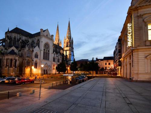 an empty street in front of a large cathedral at Mercure Cholet Centre in Cholet