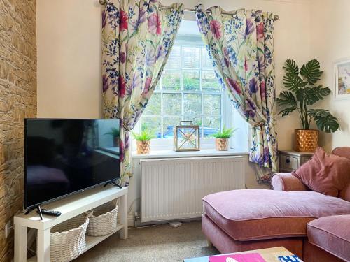 un soggiorno con TV e finestra di Issys Cottage a Helston