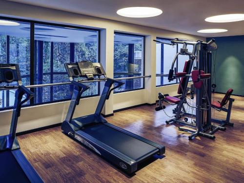 a gym with two treadmills and two ellipticals at Mercure Iguazu Hotel Iru in Puerto Iguazú