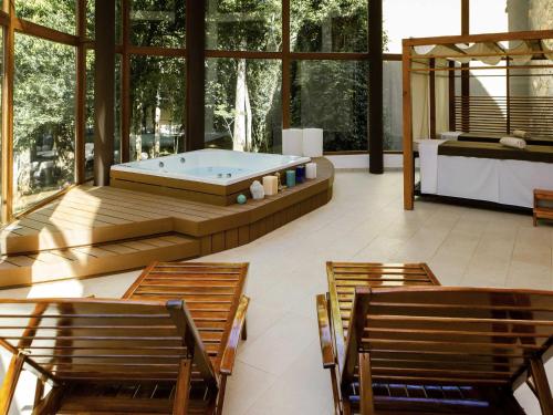 a large room with a pool and chairs at Mercure Iguazu Hotel Iru in Puerto Iguazú