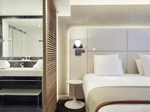 a hotel room with a bed and a bathroom at Mercure Hotel Golf Cap d'Agde in Cap d'Agde