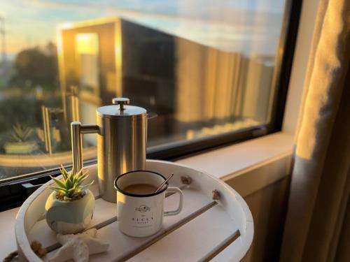 a cup of coffee on a plate next to a window at Vitamin Sea Beach House in Riverton