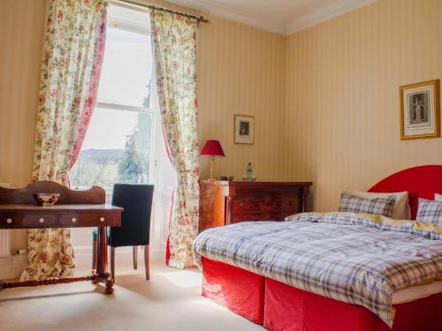a bedroom with a bed and a desk and a window at Dalnaglar Castle - Uk7072 in Cray