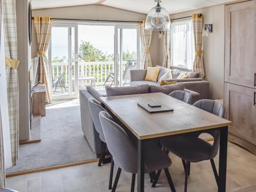 een woonkamer met een tafel en stoelen bij Seaview One - Uk50167 in Corton