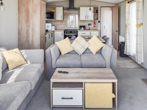 een woonkamer met twee banken en een tafel bij Seaview One - Uk50167 in Corton
