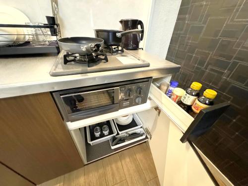 a kitchen with a stove with a pan on it at K2 square 502 in Nagoya