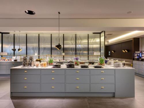 a large kitchen with a large white counter top at Mercure Hotel Wiesbaden City in Wiesbaden