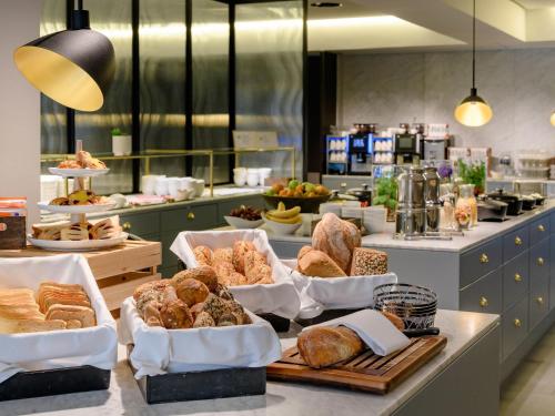 a bakery with many different types of bread on a counter at Mercure Hotel Wiesbaden City in Wiesbaden