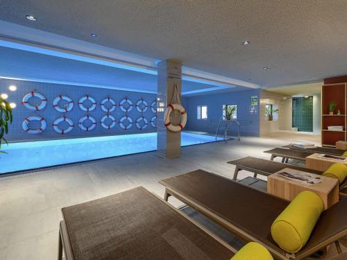 a living room with a large aquarium in the wall at Mercure Hotel Wiesbaden City in Wiesbaden