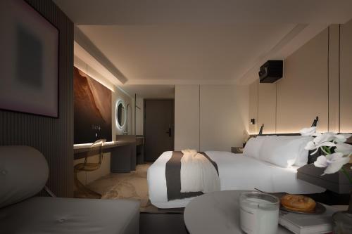 a hotel room with a large bed and a table at 重庆MAX范思酒店解放碑来福士店Chongqing MAX Van Hotel Jiefangbei Raffles in Chongqing