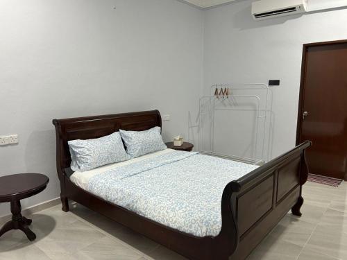 a bedroom with a bed and a table at Rumah Sungai Impiana PCB in Kota Bharu