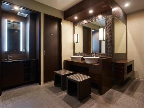 a bathroom with two sinks and a large mirror at Mitsui Garden Hotel Shiodome Italia-gai - Tokyo in Tokyo