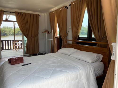 a bedroom with a large white bed with windows at Rumah Sungai Impiana PCB Room 7 in Gua Sai
