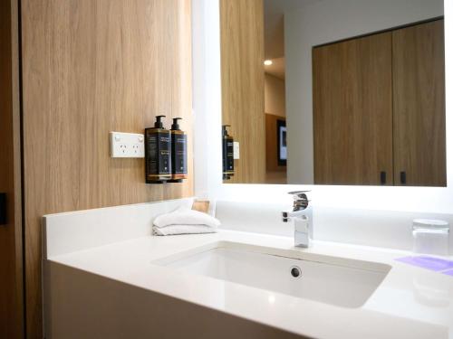 a bathroom with a white sink and a mirror at Mercure Penrith in Penrith