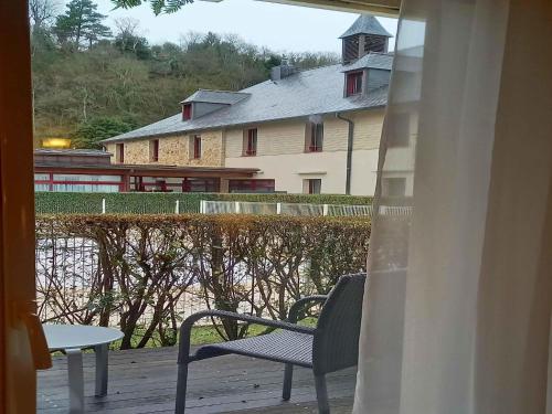 a patio with a chair and a table and a building at Mercure Dinan Port Le Jerzual in Dinan