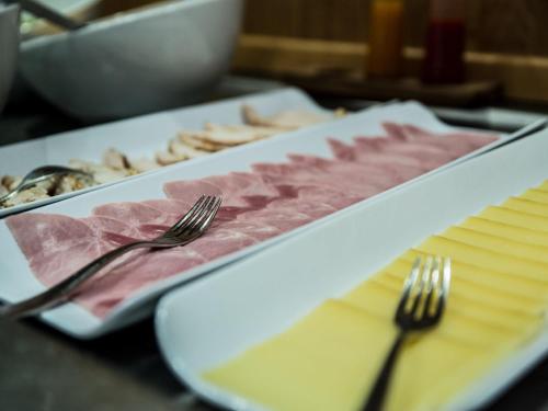 a plate of meat on a table with a fork at Mercure Dinan Port Le Jerzual in Dinan