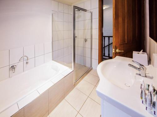 a bathroom with a tub and a sink and a shower at Mercure Ballarat Hotel & Convention Centre in Ballarat