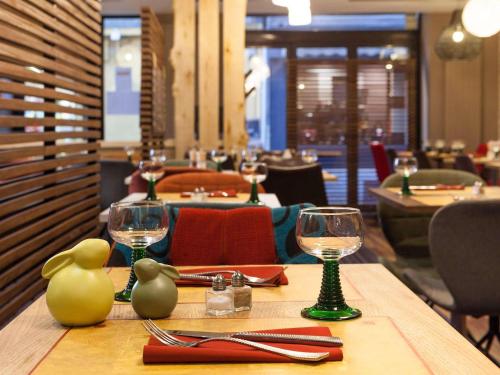 a table in a restaurant with wine glasses on it at ibis Styles Chaumont Centre Gare in Chaumont