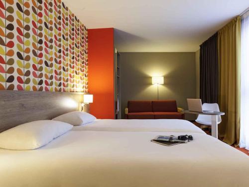 a hotel room with a large bed and a chair at ibis Styles Chaumont Centre Gare in Chaumont