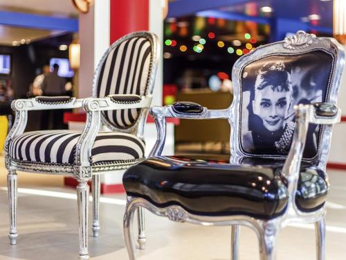 two chairs with a picture of a man sitting on them at Ibis Styles Porto Alegre Centro in Porto Alegre