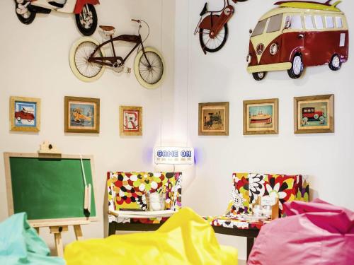 a room with a classroom with a green chalkboard and bikes on the wall at Ibis Styles Porto Alegre Centro in Porto Alegre
