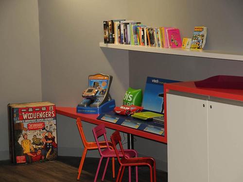 a desk with two chairs and a table with toys at Ibis Styles Chambery Centre Gare in Chambéry