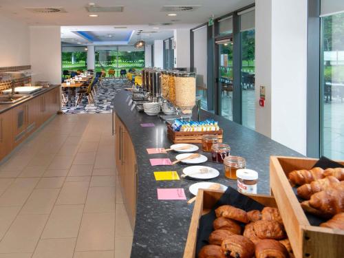 a bakery with a long counter with pastries on it at ibis Styles Crewe in Crewe