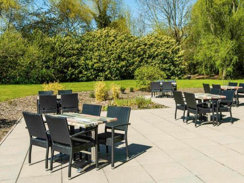 a group of tables and chairs sitting on a patio at ibis Styles Crewe in Crewe