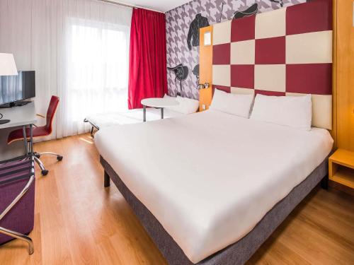 a hotel room with a large bed and a tv at ibis Styles Haydock in Haydock