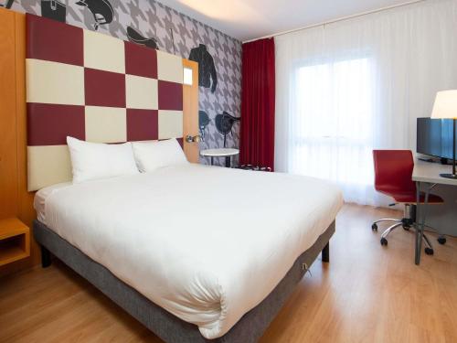 a bedroom with a large bed and a checkerboard wall at ibis Styles Haydock in Haydock