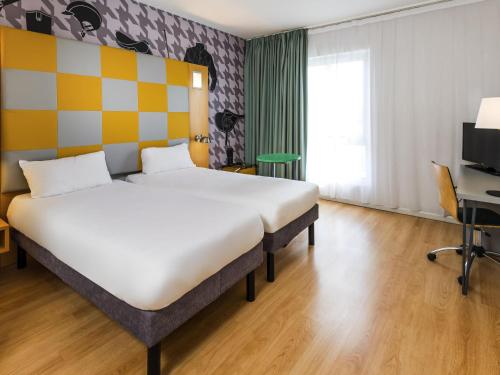 a bedroom with a large bed in a room at ibis Styles Haydock in Haydock