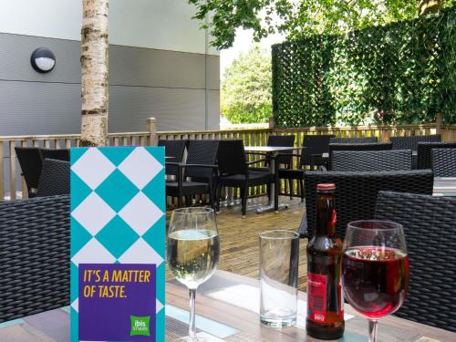 a table with two glasses and a bottle of wine at ibis Styles Haydock in Haydock