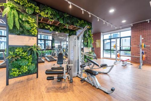 a gym with exercise equipment and plants on the walls at Cozy Mayfair Homestay in Puchong