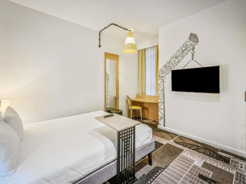 a bedroom with a bed and a tv on a wall at ibis Styles Glasgow Centre George Square in Glasgow