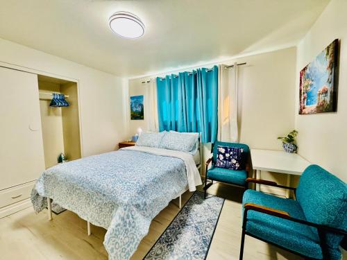 a bedroom with a bed and two blue chairs at 1 Bedroom Mini Apartment 10 Minutes to SeaTac Airport 1 Minute Walk to Bus Station in Seattle