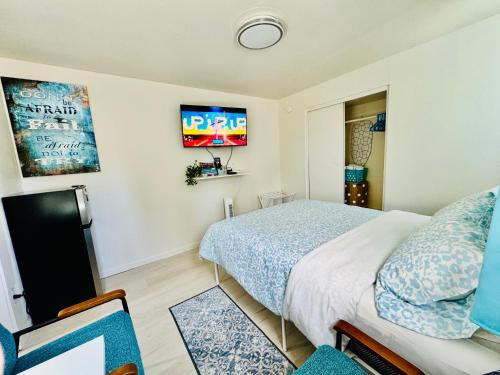 a bedroom with a bed and a tv on the wall at 1 Bedroom Mini Apartment 10 Minutes to SeaTac Airport 1 Minute Walk to Bus Station in Seattle