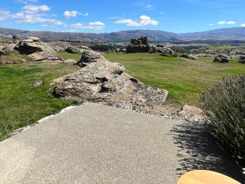 a rock sitting on top of a grassy field at Mountain and river view retreat in Alexandra
