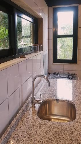 a kitchen with a sink and two windows at Mapuche de Puntanegra in Punta Colorada