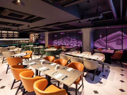 a restaurant with tables and chairs in a room at ibis Styles Ambassador Seoul Myeong-dong in Seoul
