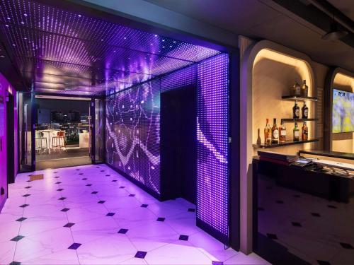 a purple room with a bar with a purple floor at ibis Styles Ambassador Seoul Myeong-dong in Seoul