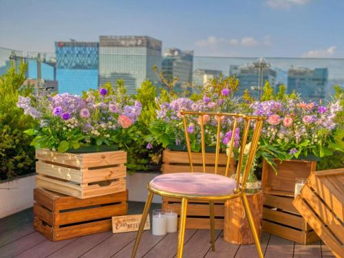 a chair sitting on a balcony with flowers at ibis Styles Ambassador Seoul Myeong-dong in Seoul