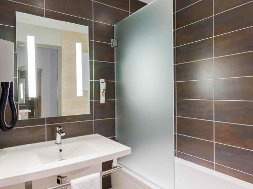 a bathroom with a sink and a mirror at ibis Styles Vierzon in Vierzon