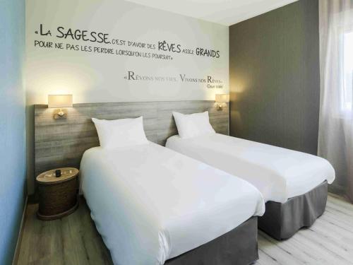 two beds sitting next to each other in a room at ibis Styles Vierzon in Vierzon