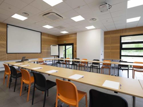 an empty classroom with a large table and chairs at ibis Styles Vierzon in Vierzon