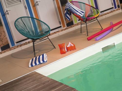 two chairs and a swimming pool in a house at ibis Styles Vierzon in Vierzon
