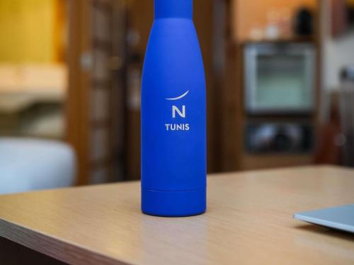 a blue bottle sitting on top of a table at Novotel Tunis in Tunis
