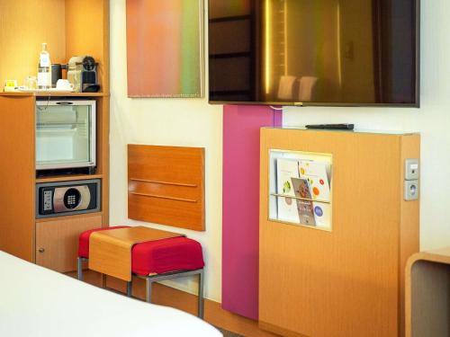 a room with a kitchen with a refrigerator and a stool at Novotel Tunis in Tunis